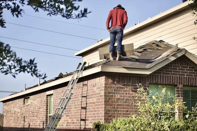 Professional roofer working on a residential roof in Frognot